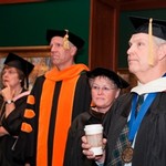 Faculty members listen for instructions before convocation starts